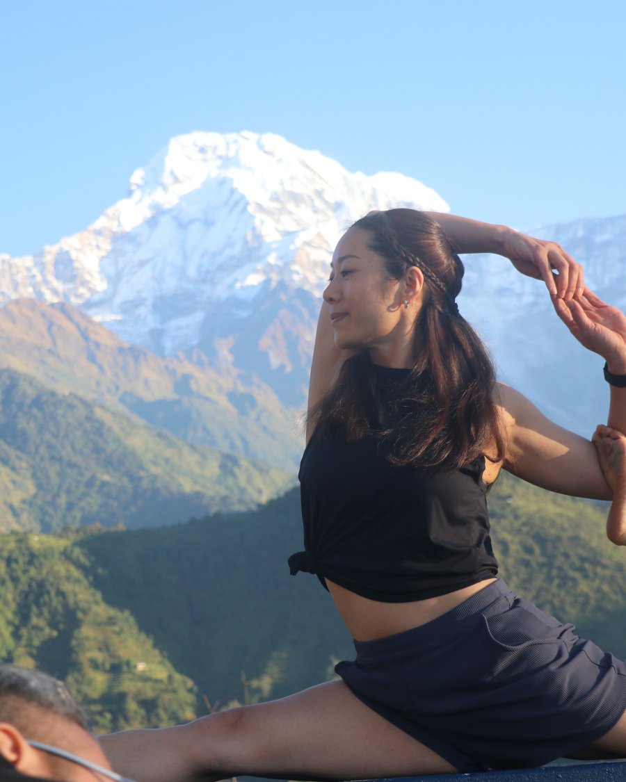 Woman in a restorative yoga pose with closed eyes in deep relaxation.