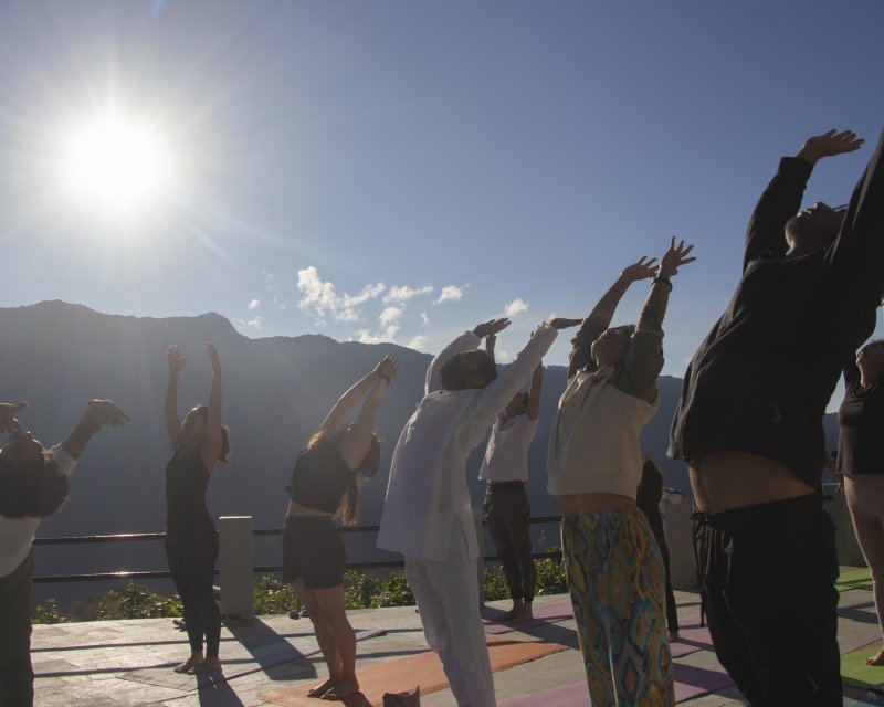 Group yoga retreat session in a serene mountain setting.