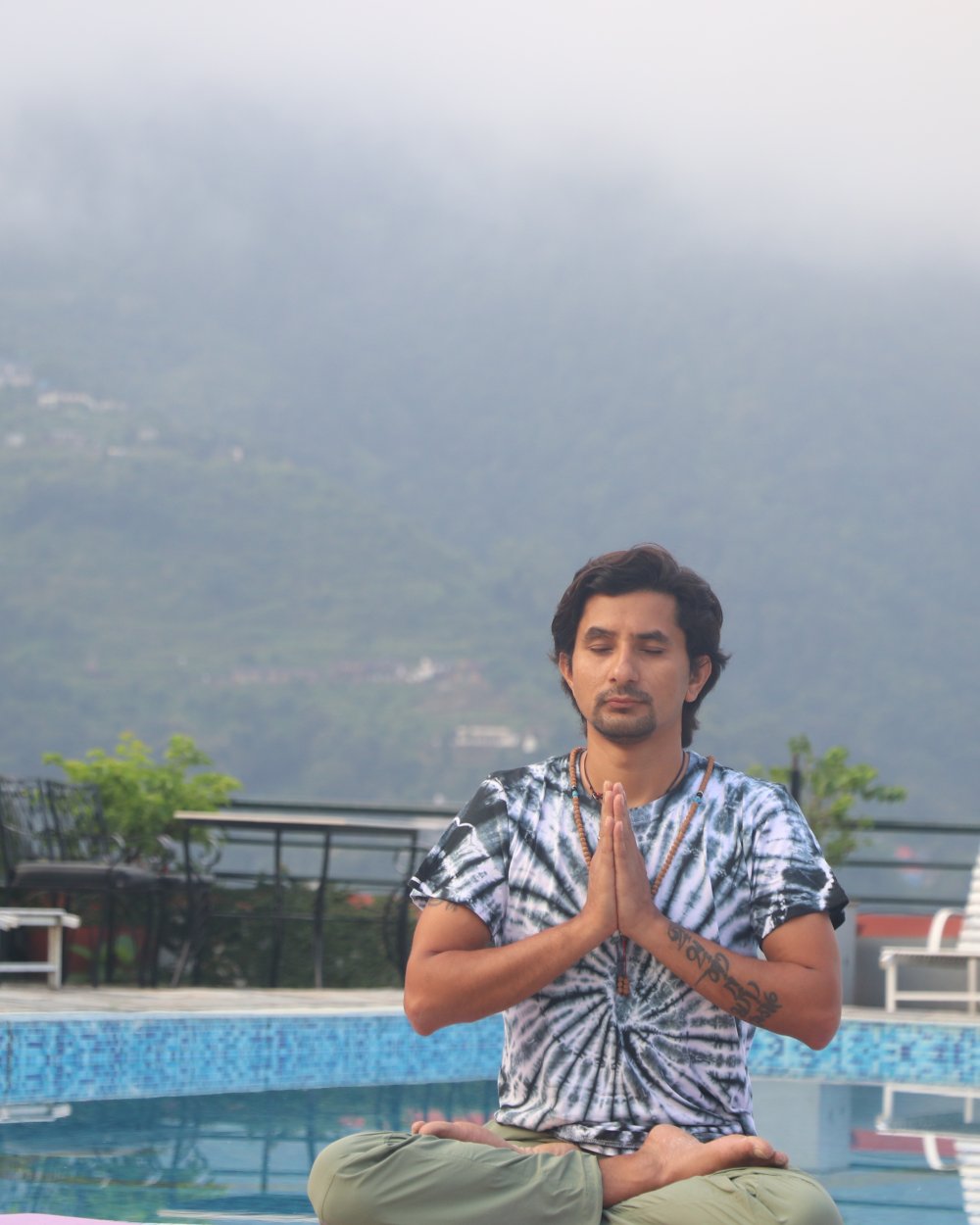 Master Akash Banjara, lead yoga teacher, in calm meditation pose.