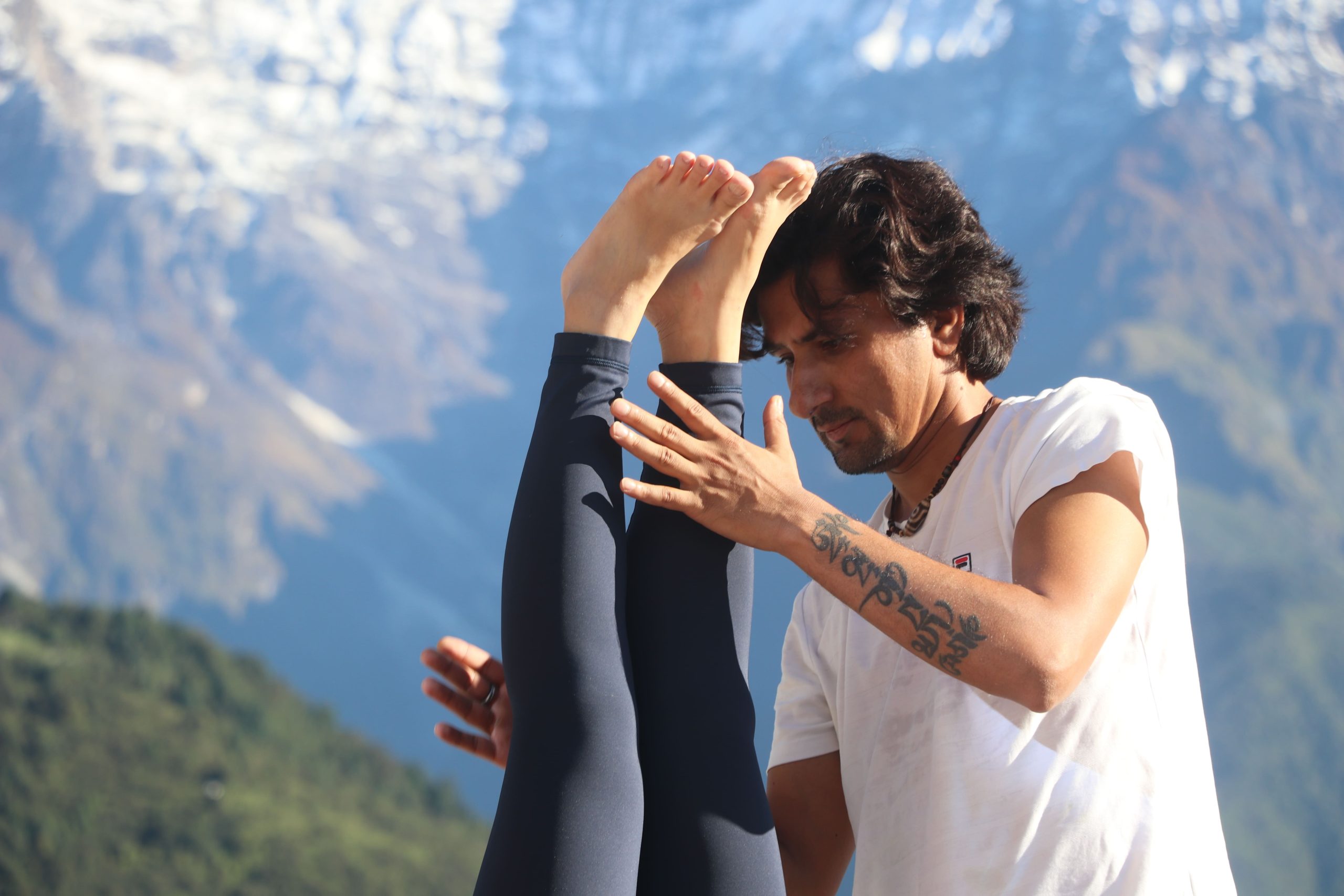 Yoga practitioner demonstrating advanced asana with Himalayan mountains in the background.